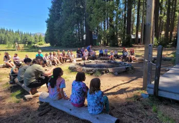 kids sitting around a fireplace daytime