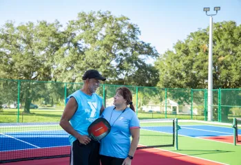 man woman on pickleball court looking at each other