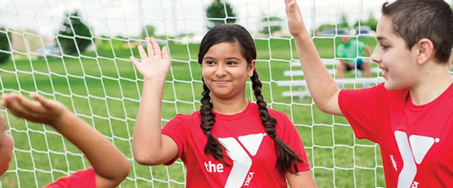 soccer goalie high fiving other kids