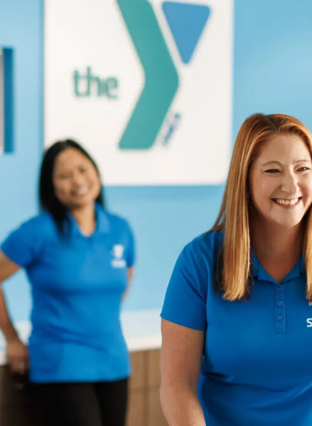 workers standig behind desk facing customer, ymca sign in background