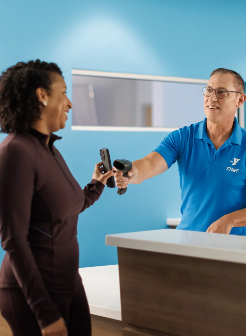 YMCA employee checking in a young woman