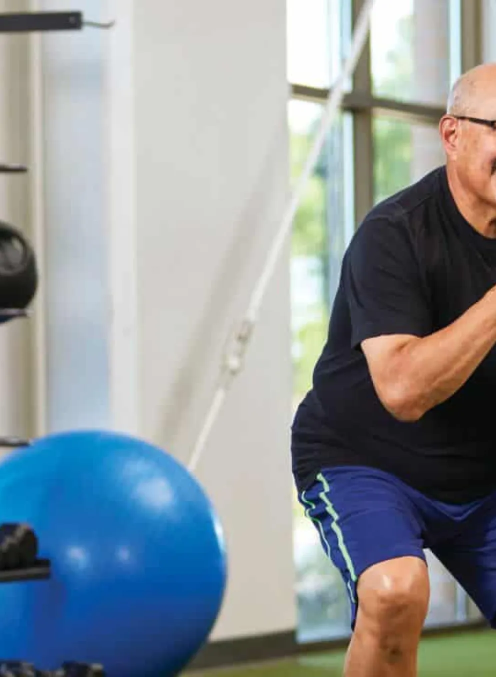 female personal trainer helping older man