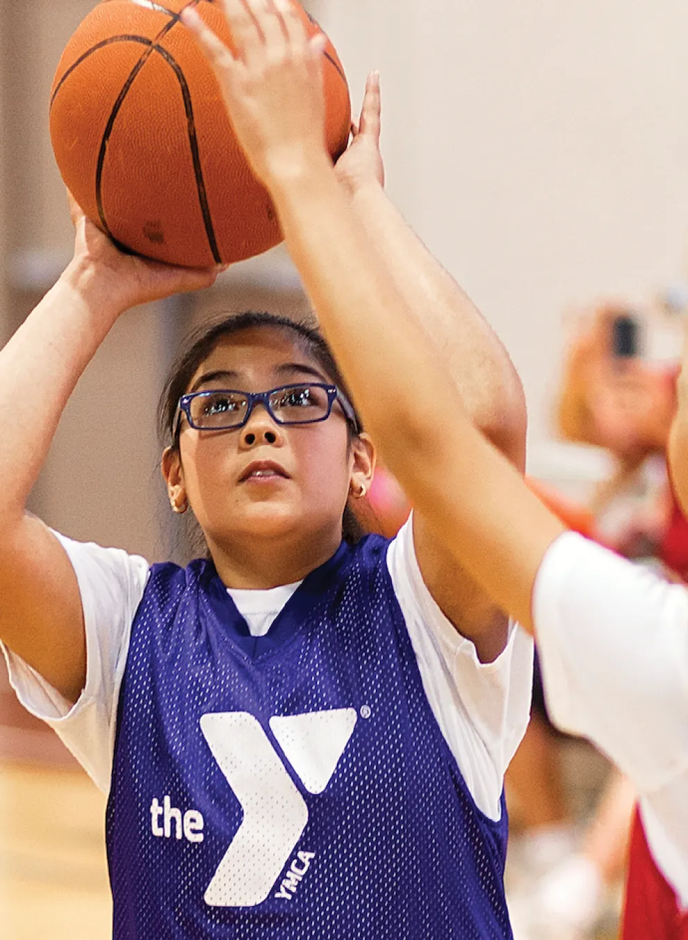 young girl shooting basketball