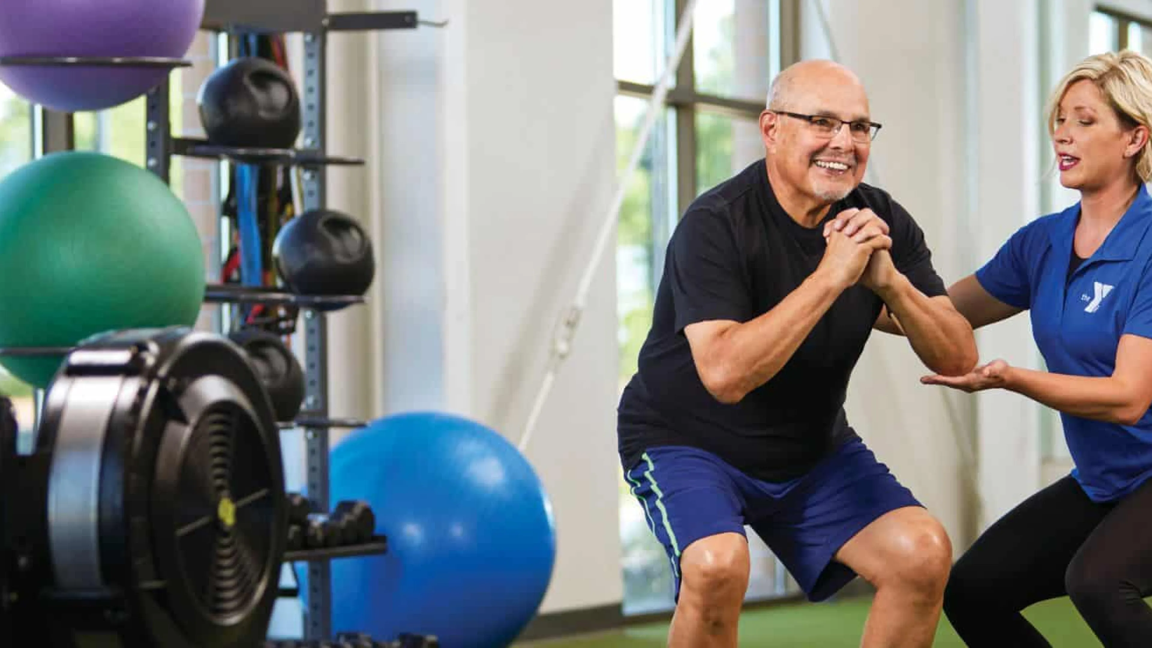 female personal trainer helping older man