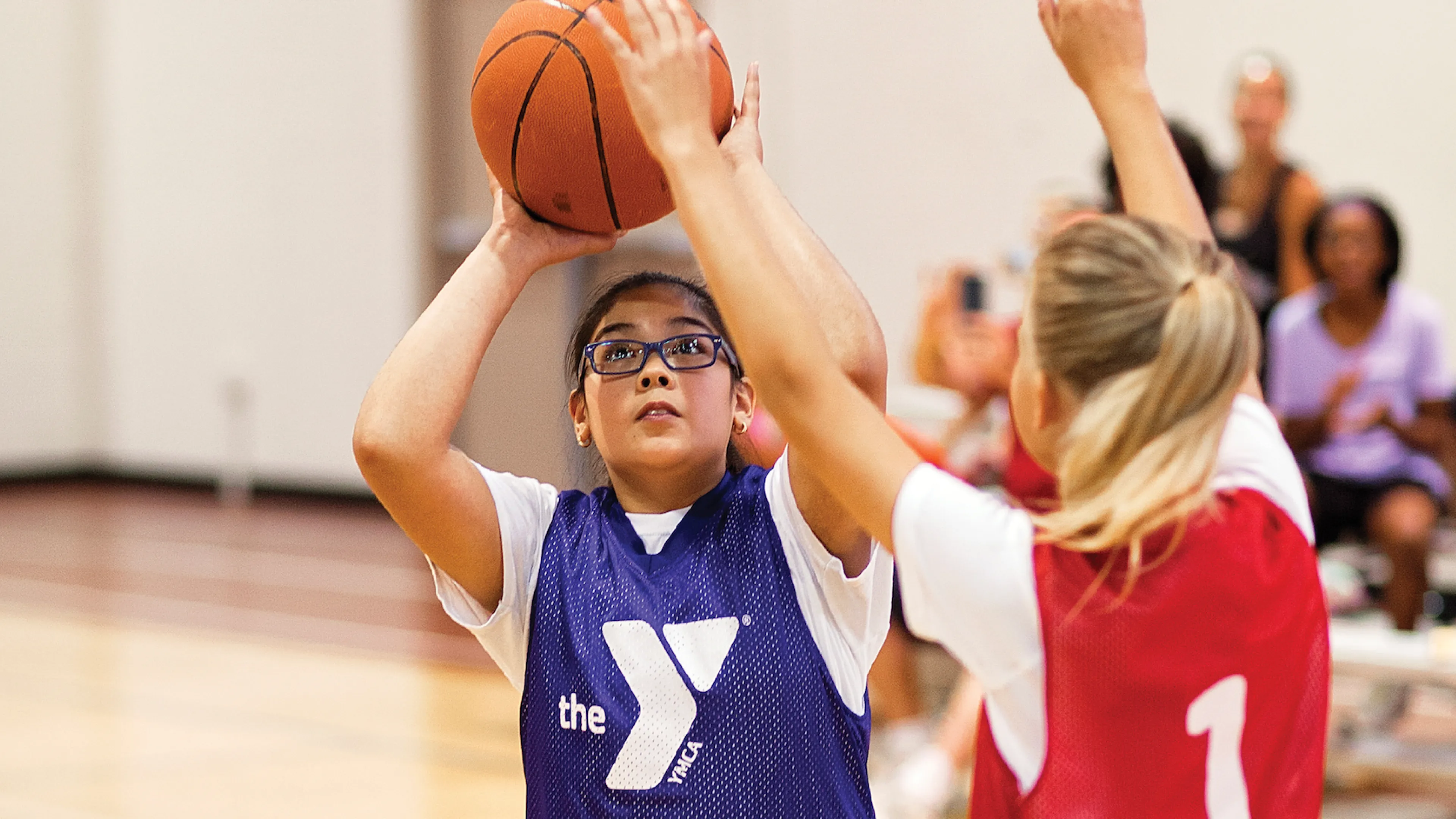 young girl shooting basketball