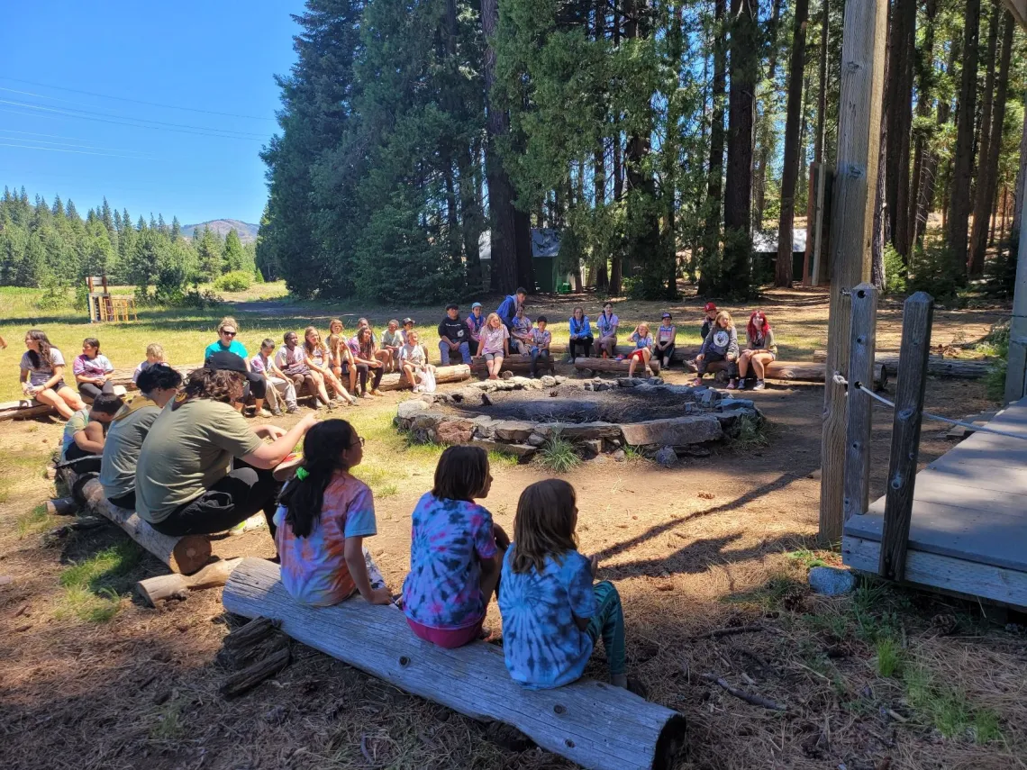 kids sitting around a fireplace daytime