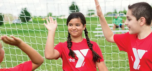 soccer goalie high fiving other kids