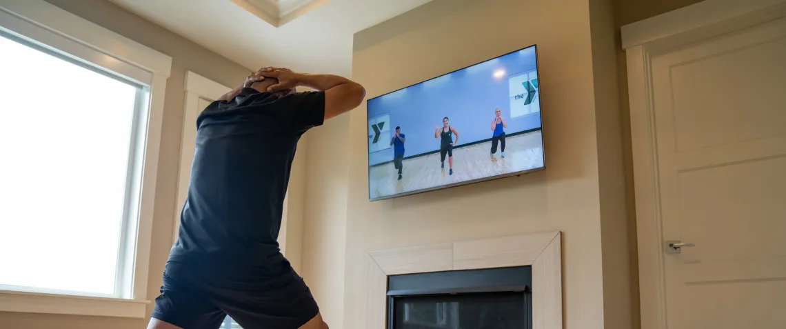 man taking virtual fitness class at home