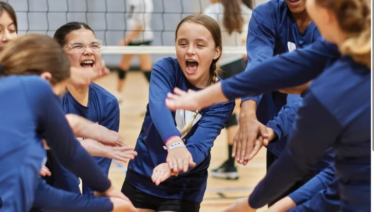 girls playing team volleyball