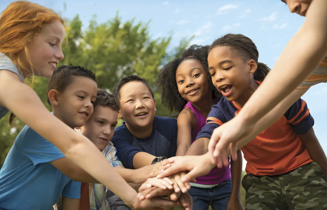 group of kids with hands in the middle