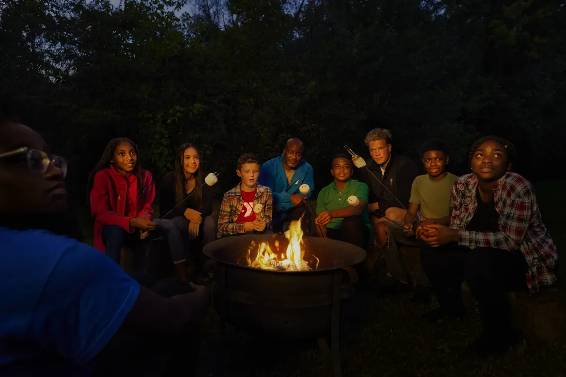 kids and adults around a camp fire