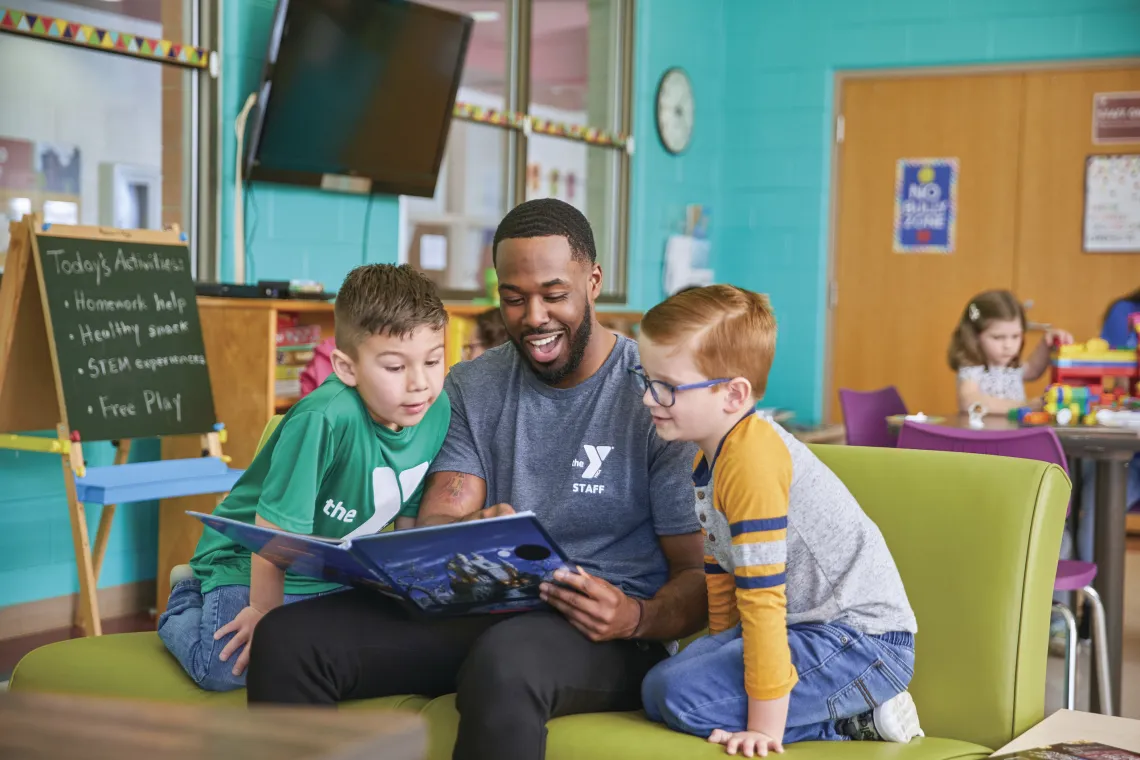 Y staff reading to two young boys