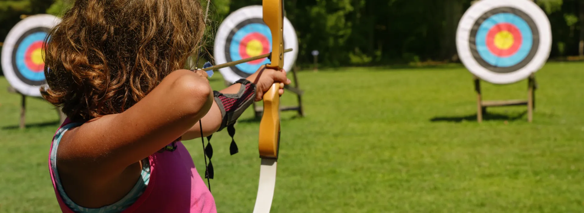 girl pointing a bow and arrow