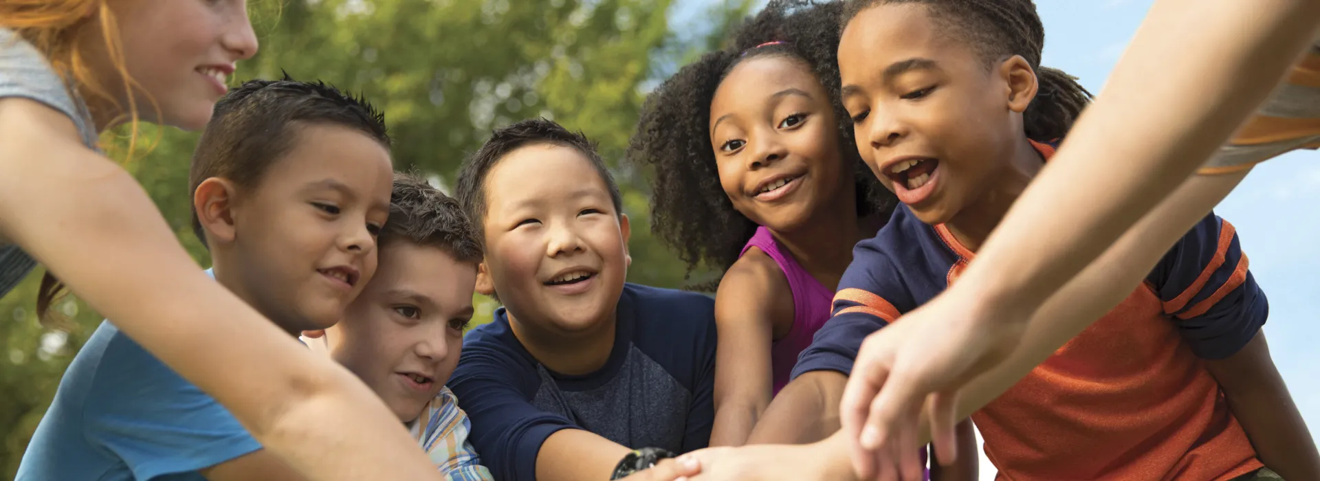 group of kids putting their hands together