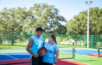 man woman on pickleball court looking at each other