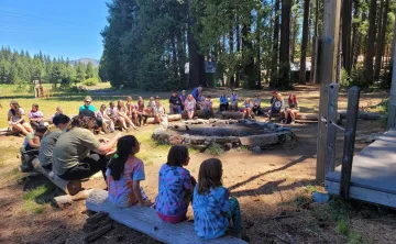 kids sitting around a fireplace daytime