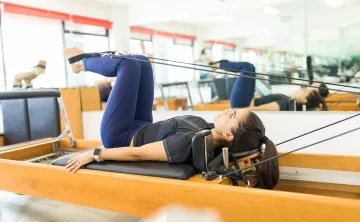 woman using pilates reformer