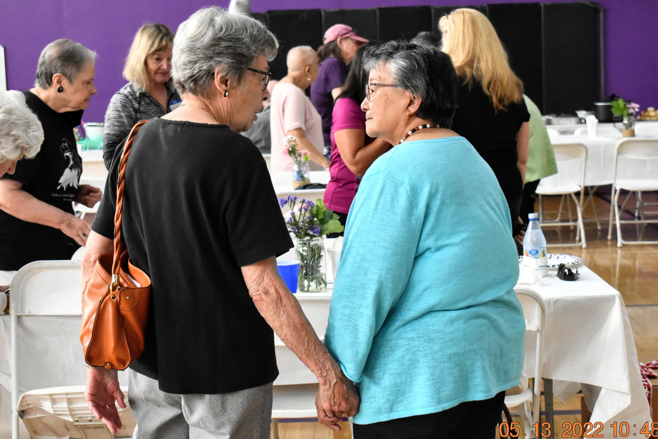 elderly women holding hands