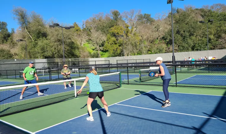 photo of four people playing pickleball